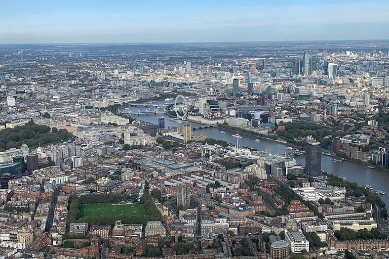 Central London from a helicopter: the Thames curving past the London Eye, with bridges and dense streets below
